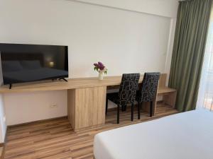 a room with a desk with a television and two chairs at Steluta in Eforie Nord