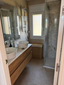 a bathroom with two sinks and a shower at Ático Jardín del Golf, Casa Alma in Chiclana de la Frontera +14 photos