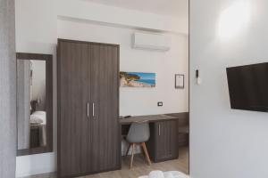 a room with a door and a desk and a television at Il mare di Giulio in Marcelli +15 photos