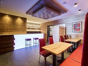 a restaurant with wooden walls and wooden tables and chairs at Hotel Garni Arnica ***S in Madonna di Campiglio