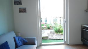 a living room with a couch and a sliding glass door at Entre Golf et Mer RDC in Dieppe +2 photos