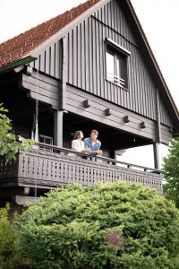 two people standing on the balcony of a house at SCHILCHERLANDLEBEN - Weingartenhaus in Sankt Stefan ob Stainz