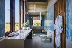 a bathroom with a sink and a toilet and a shower at SaffronStays Citadel in Sangolda +19 photos