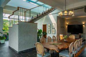 a dining room with a wooden table and chairs at SaffronStays Citadel in Sangolda