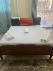 a large bed with white sheets and pillows on it at Heavenly homes apartment in Mombasa