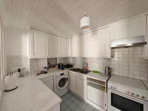 a kitchen with white cabinets and a washing machine at Hidden Gem Convenient & Spacious in Andros