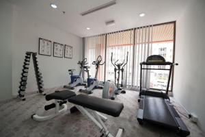 a gym with cardio equipment in a room with a window at Gaya Centre Hotel in Kota Kinabalu