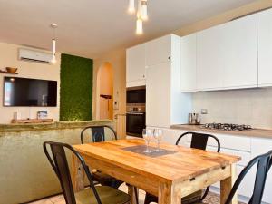 a kitchen with a wooden table with wine glasses on it at Appartamento Mango in Cavallino-Treporti