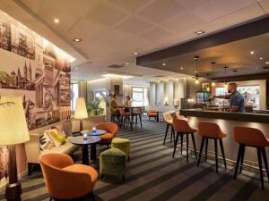 a restaurant with a bar and tables and chairs at Mercure Caen Centre Port De Plaisance in Caen