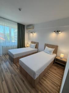 a hotel room with two beds and a window at Steluta in Eforie Nord