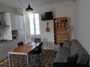 a living room with a table and a couch and a kitchen at Piccolo Lago in Travedona