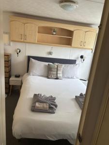a bedroom with a large white bed with towels on it at 11 Oaklands in Porchfield +20 photos