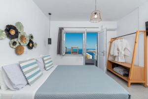 a bedroom with a bed and a view of the ocean at Gizis Cliffside Suites in Imerovigli