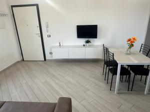 a dining room with a table and a tv on a wall at Portunno Relax House in Fiumicino
