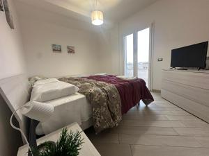 a bedroom with a bed and a flat screen tv at Portunno Relax House in Fiumicino