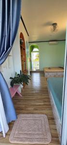 a room with a bath tub and a wooden floor at Gió Homestay and Coffee in Ấp Khánh Phước (1)
