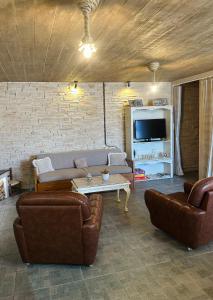 a living room with two couches and a tv at Hill House in Kavála