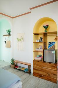 a room with a bed and a tv on a shelf at Gió Homestay and Coffee in Ấp Khánh Phước (1)