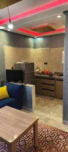 a living room with a blue couch and a kitchen at Tata hôte in Tatta +4 photos