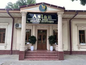 a building with a sign for a hotel at Aslan Hostel in Samarkand