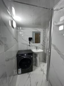 a bathroom with a sink and a washing machine at Aslan Hostel in Samarkand +12 photos