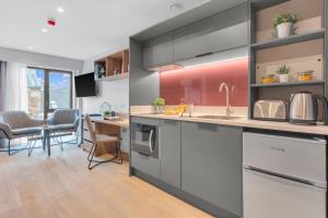 a kitchen with stainless steel appliances and a dining room at The Bonnie in Glasgow +8 photos