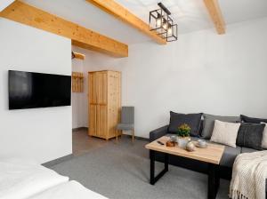 a living room with a couch and a table at Golden Apartments - Villa Taternik - Tatry View in Zakopane