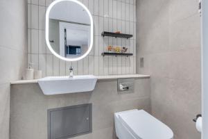 a bathroom with a sink and a toilet and a mirror at The Bonnie in Glasgow