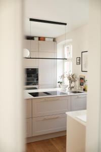 a white kitchen with white cabinets and a stove at Altes Winzerhaus Stegmann in Sankt Martin