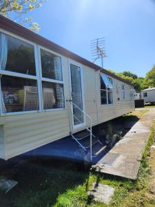 a mobile home with a porch and a staircase at 11 Oaklands in Porchfield
