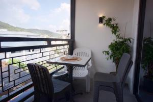 a balcony with a table and chairs and a window at Yanna's Unit - 3Bedroom with Breakfast in Baguio