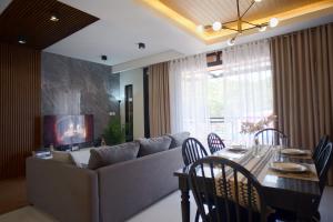 a living room with a couch and a table with chairs at Yanna's Unit - 3Bedroom with Breakfast in Baguio