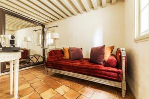 a living room with a red couch with pillows at La Maison d'Uzès Relais & Châteaux in Uzès