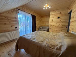 a bedroom with a bed in a room with wooden walls at Pulmo Rest House in Pulʼmo