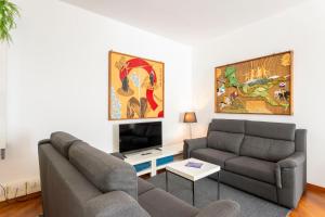 a living room with two couches and a tv at Piazzetta Lake View by Halldis in Dongo
