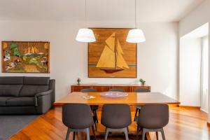 a dining room with a table and a sailboat on the wall at Piazzetta Lake View by Halldis in Dongo