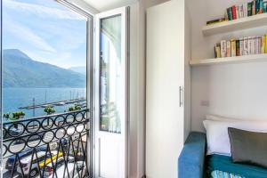 a bedroom with a balcony with a view of the water at Piazzetta Lake View by Halldis in Dongo