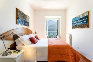 a bedroom with a large bed and a window at Piazzetta Lake View by Halldis in Dongo