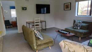 a living room with two chairs and a table at Amblers Rest Accomodation in Drury +5 photos