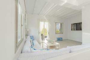 a white living room with two white couches and a table at Eidolion Essence - Mykonos Villa with Private Pool in Ano Mera