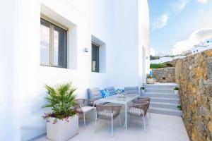 a patio with a table and chairs and stairs at Eidolion Essence - Mykonos Villa with Private Pool in Ano Mera