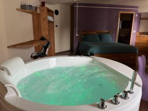 a bath tub with green water in a room at Lo Berio Morgex in Morgex