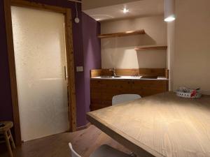 a kitchen with a table and a sink and a door at Lo Berio Morgex in Morgex