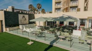 an outdoor patio with tables and chairs and umbrellas at Medplaya Hotel Pez Espada in Torremolinos