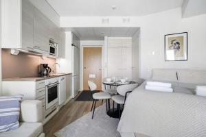 a small apartment with a bed and a small kitchen at Modern Arctic Studio By Lapland Host in Rovaniemi +3 photos