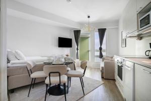 a kitchen and living room with a table and chairs at Modern Arctic Studio By Lapland Host in Rovaniemi