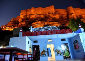 ein weißes Gebäude mit einem Berg im Hintergrund in der Unterkunft L G Guest House in Jodhpur
