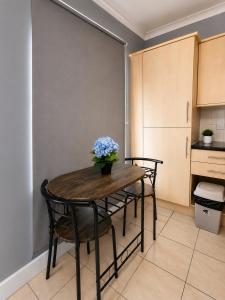 a dining room table with a vase of flowers on it at Catherines House Kings Cross Area in London +22 photos