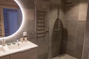 a bathroom with a shower with a sink and a mirror at Sommarbukt Tind - Luxury Fjord Lodge near Tromsø in Tromsø