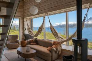 a living room with a couch and a large window at Sommarbukt Tind - Luxury Fjord Lodge near Tromsø in Tromsø